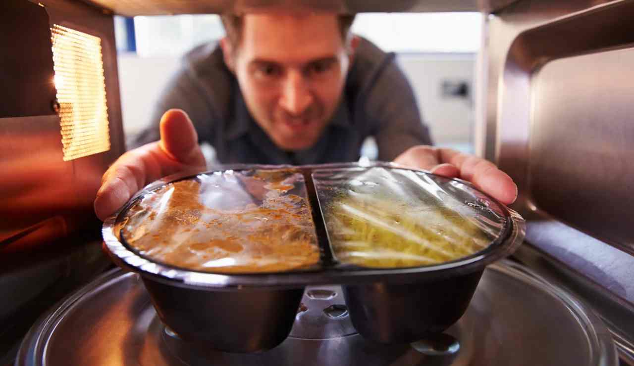 Uomo che usa il microonde